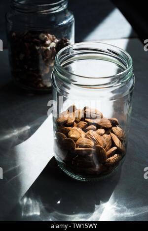 Pot d'amandes crues organiques avec lumière naturelle prêt à manger. Des collations santé. Banque D'Images