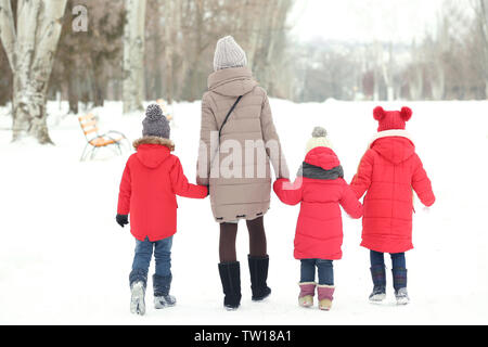 Jeune femme avec des enfants de marcher sur la neige Banque D'Images