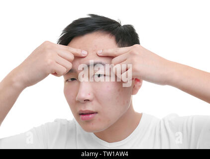 Young Asian man popping boutons, sur fond blanc Banque D'Images