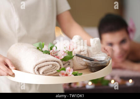 Masseur féminin holding tray with spa produits de thérapie dans un centre de bien-être Banque D'Images