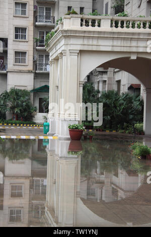 Reflet d'un immeuble d'appartements dans l'eau, Gurgaon, Haryana, Inde Banque D'Images