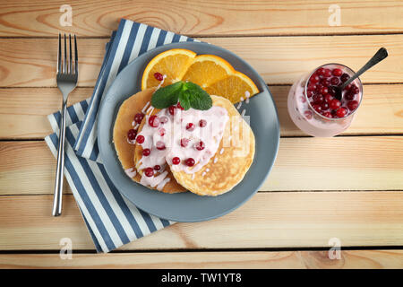 Le yogourt savoureux pancakes de tranches d'orange et fruits rouges sur la table, vue du dessus Banque D'Images