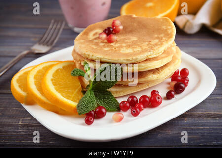 Délicieuses crêpes aux fruits rouges et des tranches d'orange sur la plaque Banque D'Images