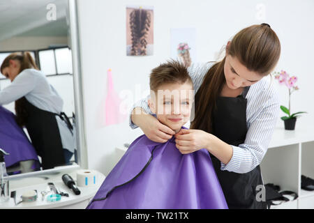 Mignon petit garçon dans le salon de coiffure Banque D'Images