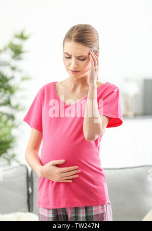 Femme enceinte souffrant de maux de tête à la maison Banque D'Images