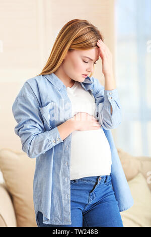 Femme enceinte souffrant de maux de tête à la maison Banque D'Images