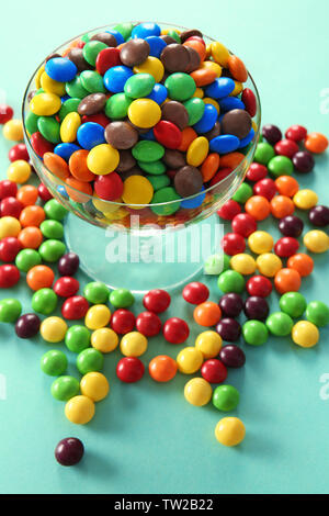 De délicieux bonbons colorés dans un bol sur un fond de couleur Banque D'Images