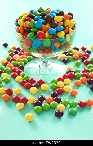 De délicieux bonbons colorés dans un bol sur un fond de couleur Banque D'Images