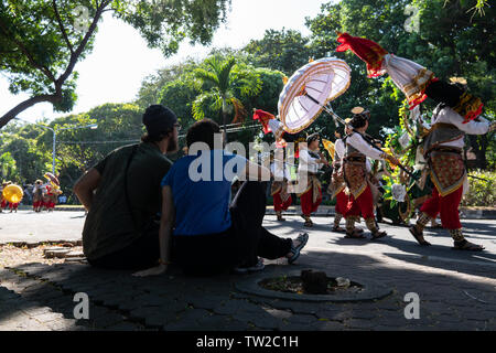 /DENPASAR BALI - 15 juin 2019 : une paire de touristes de l'Europe suivent une parade de danse traditionnelle à l'ouverture de la partie Arts Bali 2019 Banque D'Images