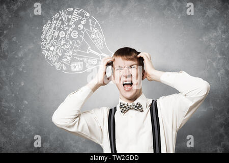 Redhead student stress garde les mains sur la tête. Jeune homme dans la panique sur fond de mur gris avec idée lightbulb esquisse les frais généraux. Gros problème Banque D'Images