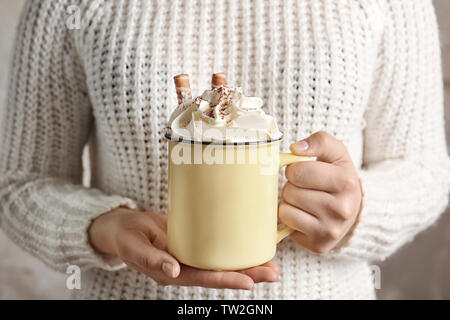 Woman holding metal tasse de boisson au cacao avec de la crème fouettée en mains Banque D'Images