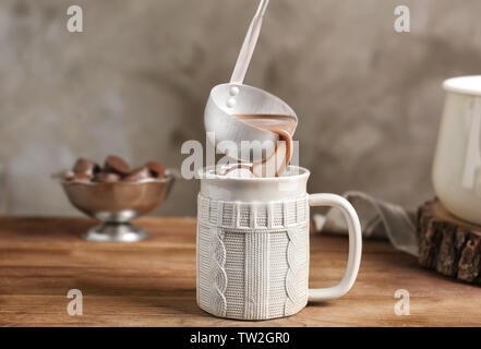 Verser dans un verre chaud cacao cup sur table de cuisine Banque D'Images