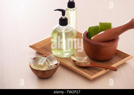 Bolw de l'aloès sur une planche à découper et gel douche bio en bouteille sur le plateau en bois Banque D'Images