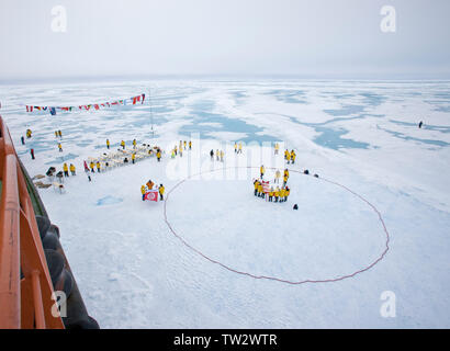 Formulaire de touristes cercle au Pôle Nord après avoir atteint 90 degrés Nord sur un brise-glace nucléaire russe de 50 ans de la victoire. Juillet 2008. Banque D'Images