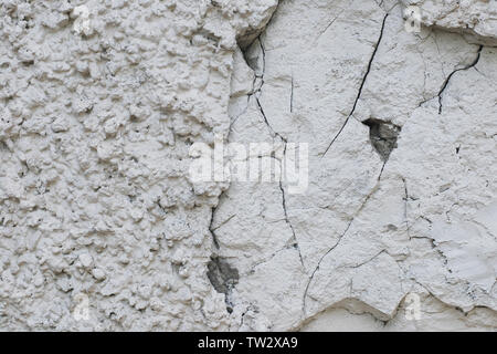 Texture grunge très rugueux de plâtre blanc, mur de pierre taillée, à moitié détruit et fissuré Banque D'Images