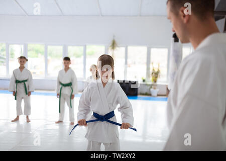 Jeune fille sérieuse. Cute little girl wearing white aikido ayant visage sérieux avant de pratiquer l'aïkido Banque D'Images