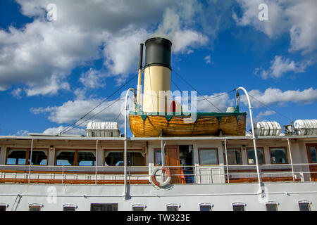 Bateau de sauvetage sur un vieux bateau avec fond nuageux Banque D'Images