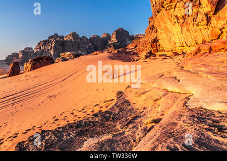 Le soleil se couche dans le désert jordanien à Wadi Rum ou la vallée de la Lune. Banque D'Images