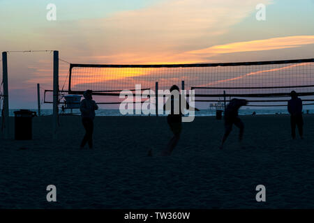 Huntington Beach, CA / 25 mars 2019 : Silhouettes de volley sur la plage au coucher du soleil à Huntington Beach, en Californie. Banque D'Images