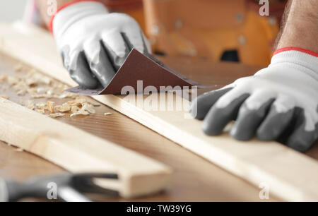 Ponçage Carpenter planche en bois sur la table, gros plan Banque D'Images