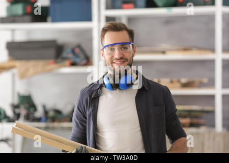 Smiling chef holding planches en bois dans l'atelier d'éclairage Banque D'Images