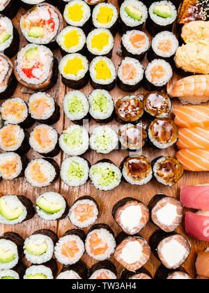 Vue de dessus d'un grand nombre de rouleaux de sushi et on wooden table Banque D'Images