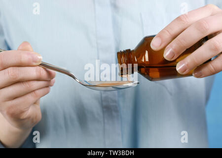 Woman pouring sirop contre la toux en cuillère, closeup Banque D'Images