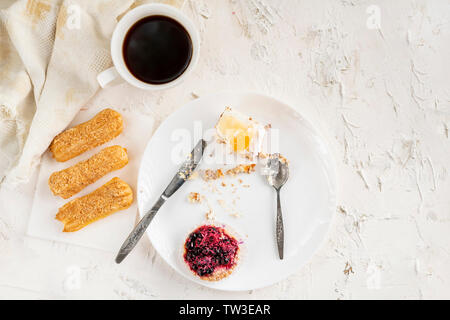 Tenir la main des personnes et de l'alimentation à la cuillère et couteau manger sucré gâteau sur une assiette, vaisselle, vue du dessus Banque D'Images