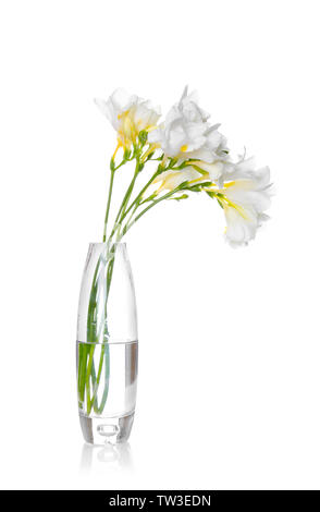 Vase en verre avec belle freesia sur fond blanc Banque D'Images
