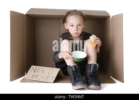 Pauvre petite fille assise dans la boîte en carton et mendier de l'argent sur fond blanc Banque D'Images