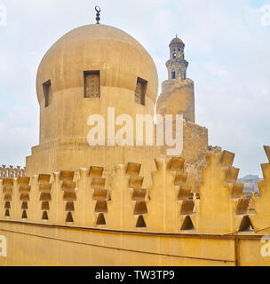 La vue à travers les mâchicoulis décoratifs sur le dôme d'Amir Sarghatmish modeste mosquée et minaret en spirale style Samarran inhabituelle d'Ibn Tulun mosquée bleue Banque D'Images