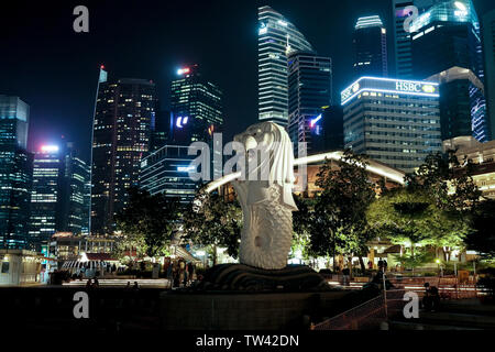 Statue du Merlion Merlion Park situé à Singapour avec l'horizon de la ville de nuit. Cette photo montre sans l'eau traditionnelle de sa bouche. Banque D'Images
