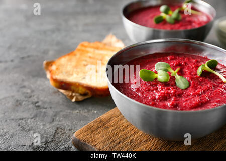 Soupe de betterave délicieux avec des germes de tournesol dans un bol sur une table de cuisine Banque D'Images