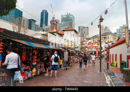 Vue générale du marché de Chinatown à Singapour en contraste avec les gratte-ciel du quartier des affaires sur une sombre journée humide avec des boutiques touristiques. Banque D'Images