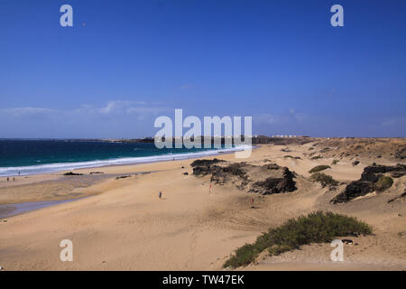 Vue sur les dunes de sable avec green ocean sur (Playa del Aljibe) le village blanc sur la falaise abrupte (El Cotillo) - Nord Fuerteventura Banque D'Images