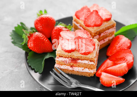 Deux morceaux de gâteau fait maison avec des fraises sur la plaque Banque D'Images