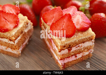 Deux morceaux de gâteau fait maison avec des fraises sur table en bois Banque D'Images