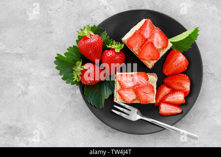 Deux morceaux de gâteau fait maison avec des fraises sur la plaque Banque D'Images