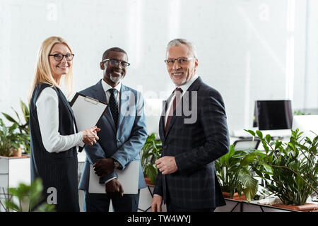 Selective focus of businessmen and businesswoman standing in office Banque D'Images