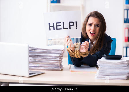 Belle jeune employé attaché avec une corde dans le bureau Banque D'Images