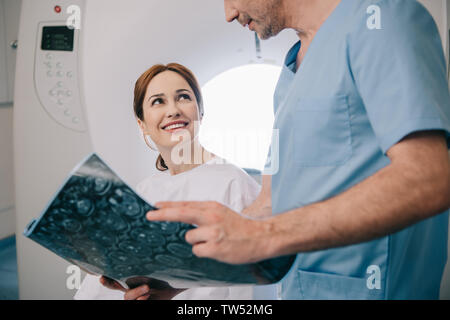 Portrait du médecin indiquant le diagnostic à rayons x à happy woman Banque D'Images