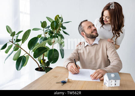 Portrait d'homme barbu à la femme heureuse au près de house et les clés sur le tableau modèle Banque D'Images