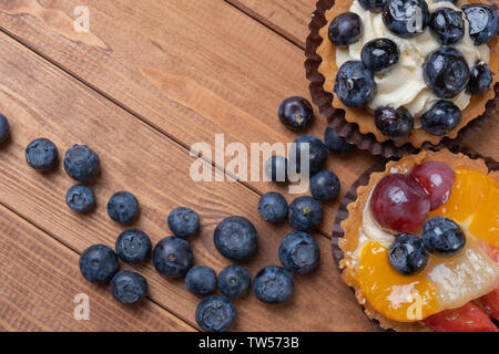 Tartelettes aux fruits sur une plaque de bois sur la table, de fruits cuits, de fruits à coque cupcake berry Banque D'Images