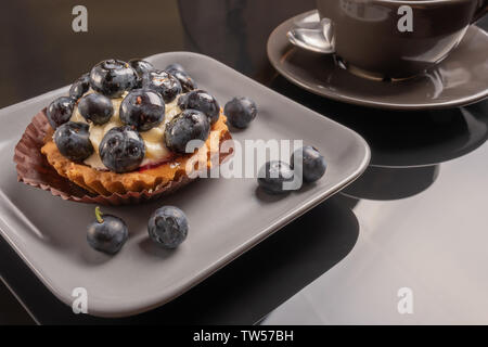 Tartelette aux fruits sur une assiette et tasse de café sur la table, de fruits cuits, de fruits à coque cupcake berry Banque D'Images