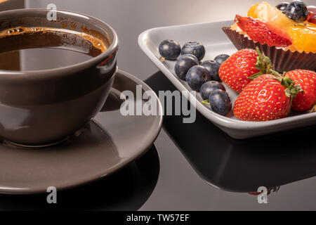 Tartelette aux fruits sur une assiette et tasse de café sur la table, de fruits cuits, de fruits à coque cupcake berry Banque D'Images