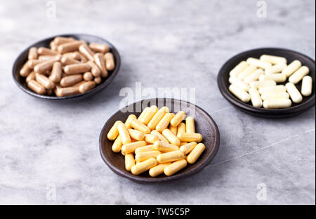 La coenzyme Q10, acide alpha-lipoïque et du thé vert gélules. Renforcement du système immunitaire. Concept pour une supplémentation alimentaire sain. Pierre lumineuse arrière-plan. Banque D'Images