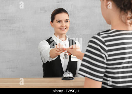 Réceptionniste femme de donner la clé de chambre d'hôtel à client Banque D'Images