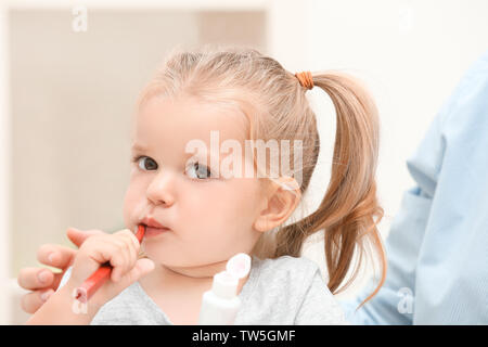 Petite fille se brosser les dents dans la salle de bains Banque D'Images