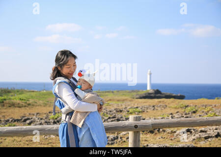 Mère et bébé asiatique il voyage en famille dans le parc en bord de mer à Zanpa Zanpa cape à Okinawa, Japon Banque D'Images