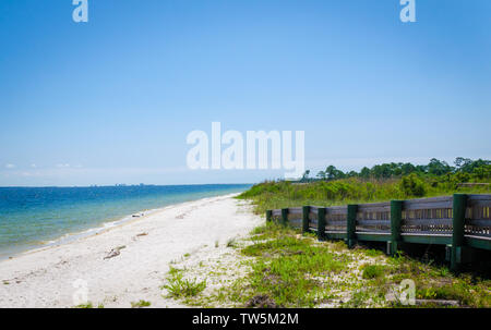 Allée de la rampe menant à la baie intercostale, plage sur l'océan avec des vagues du rivage éclaboussant à terre. Pensacola, FL, USA en arrière-plan. Banque D'Images